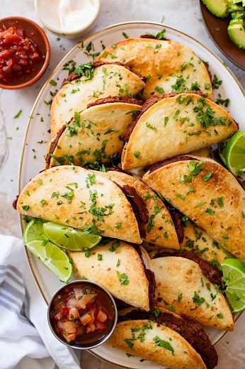 These Mini Refried Bean Tacos are INCREDIBLY simple to make, so tasty and perfect for an easy dinner or game day snack! #thissavoryvegan #superbowl2024 #superbowlrecipes #appetizers #partyfood #tacos | This Savory Vegan