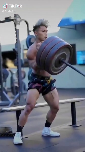 Muscular Male Weightlifting Techniques in Gym