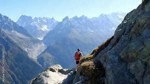 Chaîne du Mont Blanc view from the Aiguilles Rouge, near Chamonix. An amazing hike to do. Tacul Geant Glacier in the back. Girl walking alone on the trail, descending from the Lac Blanc.