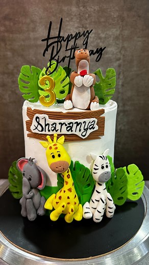 Step into the cutest little jungle you’ve ever seen — where lions roar softly, elephants smile, giraffes peek shyly, and even a tiny dinosaur joins the party! 🦁🐘🦒🦖 This jungle-themed cake is straight out of a dream, perfect for a baby’s first birthday, a toddler’s special day, or just anyone who loves adorable animal cake toppers. Every detail is handcrafted with love, from fondant leaves to those teeny paws! Inside this whimsical creation is a soft vanilla sponge layered with fresh strawber