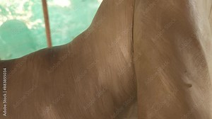 Craftsman making a clay sculpture of Mythological Greek art called Fallen Warrior (Fallen Trojan warrior, Dying warrior). Closeup shot - Indian artist creating statue of Greek and Roman Sculpture.