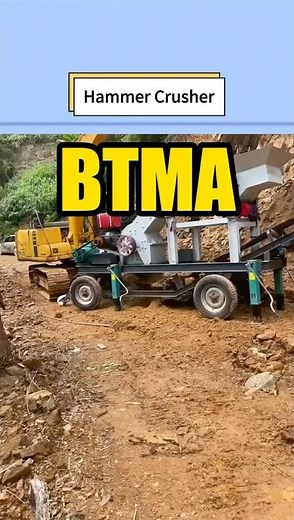 Mobile diesel hammer crusher crushes rocks and makes fine sand in mountainous field.