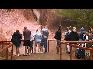 Rare waterfalls on Uluru as first significant rain falls in three years