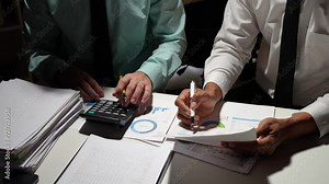 Businessman analyzing cost graphs in a conference room with a calculator and laptop with the new project of finance and accounting Presenting ideas and strategic plans at investment meetings.