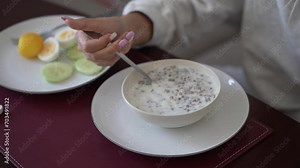 Buckwheat porridge, Pouring milk into the bowl with wheat buckwheat bran cereal. Healthy breakfast concept, Breakfast. Buckwheat Porridge with Milk in White Bowls and Pastries nearby. Top View
