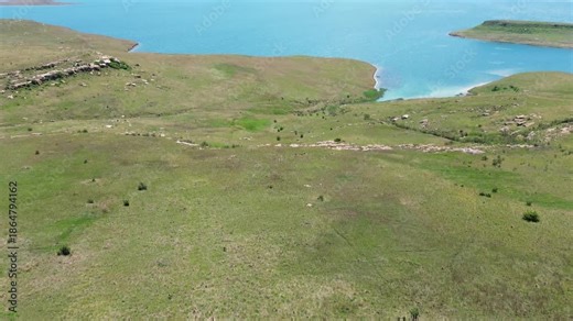 Camera panning over the Sterkfontein dam with the foothills of the Drakensberg mountain range in the background. 4K Aerial video.