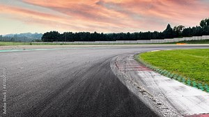 Motorsport background curve curb detail asphalt track surface level view, empty competition car circuit no people, scenic landscape sunset sky