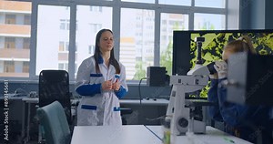 Students Looking Through Microscope And Teacher Explaining Chemical Structure Of Materials