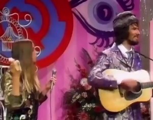 An upset Michelle Phillips eating a banana during the Mamas and the Papas performance of “California Dreaming” on the Ed Sullivan Show because they had to lip sync, 1967. | Vintage Everyday