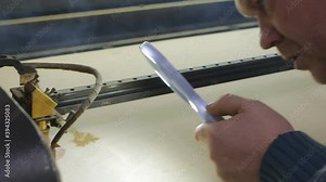 Caucasian male design engineer testing the laser head on a laser engraving and cutting machine. He looks through a magnifying glass how the laser works Stock Video