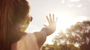 Close up back view of a woman looking at the son and hiding herself from the son with her hand. young woman with dreads playing Premium Stock Video Footage