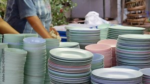 hands of a woman drying the dishes in the kitchen wiping them off with a dish towel