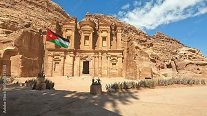 Petra, Jordan : Jordanian flag waving in front of the monastery (Ed-Deir) the Rose City - one of the Seven Wonders of the World (Petra is the cap