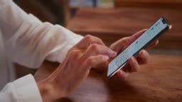 An old woman writes messages on a smartphone. The senior female...