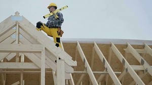 Worker on the Newly Developed Wooden House Frame