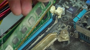 Service for repair and cleaning of computer equipment. the master takes out a dusty memory card from the motherboard.