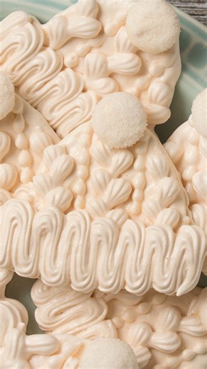 Don’t these cable knit hat meringue cookies just make you want to snuggle up with a cup of hot cocoa? My vanilla flavored meringue cookie recipe has a hint of salted caramel and it’s perfect for creating these fluffy, melt-in-your-mouth sweet treats. Get the recipe below! #baking #meringuecookies #winterbaking | SweetAmbs