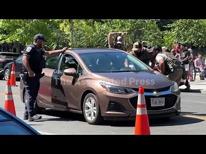 Police and officers from federal agencies stop cars in DC checkpoint as neighbors yell and observe