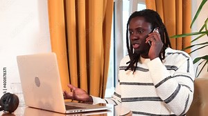 Afro man calls support by phone, reports a breakdown of the Internet in a laptop. Randomly presses the keys with his hand, speaks emotionally. Communication using the telephone network.
