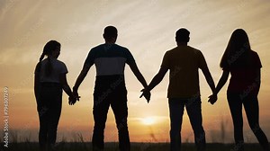 Teamwork. Silhouette of happy family. People holding hands together. Unity and trust in business. Holiday picnic in nature. Success in family business.Teamwork of friends together.Happy family concept