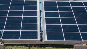 Photovoltaics solar panels in a solar park. Solar panels on green grass and blue sky. Solar panels system power generators. Alternative power energy concept.