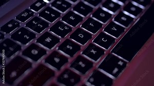 Backlit laptop keyboard in a dark room. Closeup of coding on screen, man hands coding html and programming on laptop screen, web development, developer. smart work. Work at home. Cyber attack