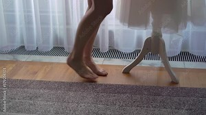 A young woman walks barefoot to her wedding dress. The bride is getting dressed. Female legs goes in bedroom.