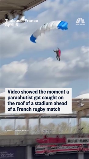 A parachutist gets caught on the stadium roof ahead of a French rugby match. | NBC News