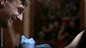 A brutal man makes himself a tattoo in a tattoo parlor. The process of creating a tattoo on the man's arm.