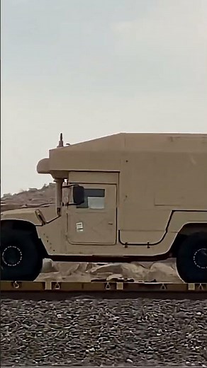 Passing train loaded with military Humvee Vehicles with different equipment