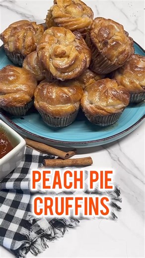 Peach Pie Cruffins are a quick and easy breakfast treat made with crescent dough and peach pie filling. Flaky layers with gooey peach pie filling for a delicious croissant muffin made in minutes. Tag and share this with your friends to try this recipe! 🍑Ingredients* 3 cans Refrigerated crescent dough 8 ounce each* 1 cup peach preserves* 1 teaspoon ground cinnamon* 1/2 cup powdered sugar* 3 tablespoons heavy whipping creamInstructions* Preheat oven to 375°.�* Grease or line a muffin tin.�* In a 
