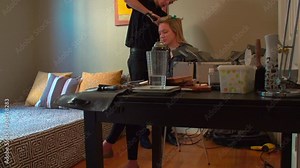 Slow-motion view of a hair artist curling a model's hair with a curling iron