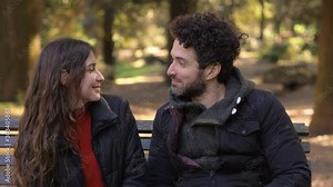 Romantic first date.Shy man kissing young woman in the park