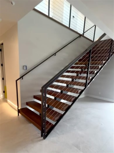 Bang Bang Designs on Instagram: "Just wrapping up another epic staircase for @boxwell_homes. Very clean, and linear with a single stringer and oversized walnut treads. The warmth of the wood treads play beautifully with the cold precision of the black steel and stainless steel lines of the cable railing. A functional architectural necessity that becomes an artistic centerpiece for the room. We call that a twofor"
