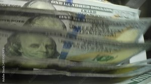 Money counting. Close up currency counting machine counting dollar bills. Machine counter calculates 100 dollars banknotes in slow motion. Closeup currency count machine counting dollar banknotes.