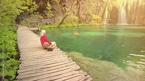 Woman in the jetty of Milino Jezero lake of Plitvice Lakes National Park in Croatia in the Lika region. UNESCO World Heritage of Croatia named Plitvicka Jezera.