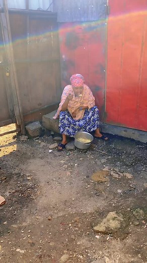 Outdoor Cooking: Woman Prepares Meal in Patterned Dress