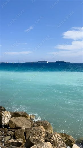 View of the Bay of Cannes with red rocks of Cap Esterel, Cannes, Cte d Azur, France. Cannes beach - France, Provence-Alpes-Cote d'Azur, View from beach to yachts in the evening. View of sea