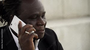 African descent man talking over the phone with happiness, and sipping coffee