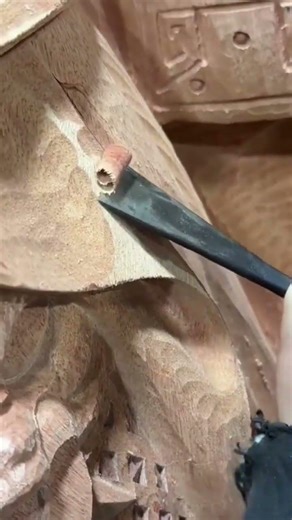 Process of creating detailed carvings on wood surface using chisel