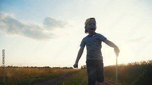 child run catching butterflies with a butterfly net in the park. happy family kid dream concept. boy run happy in the park with butterfly net silhouette. kid fun and butterfly net dream