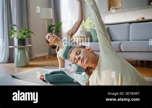 Closeup tranquil girls breathing deeply stretching indoors. Calm sportive family with closing eyes relaxing together at white home. Attractive yoga mother daughter making inhaling exercises training Stock Video Footage - Alamy