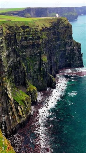 Vertical aerial drone view of the Cliffs of Moher in Ireland. Dramatic coastal cliffs and the vast Atlantic Ocean. One of the most beautiful natural landmarks in Ireland.