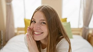 Intriguing blonde woman, telling a juicy secret, whisper-talking in a cosy room, shockwaves of gossip flowing from her hand to her mouth, enticing conversation among pyjamas in bed