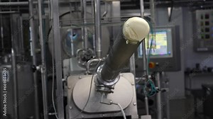 Manufacture of industrial butter in a better industrial churn. Food processing plant. Finished dairy product at production line