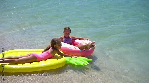 Little girls having fun at tropical beach during summer vacation playing together