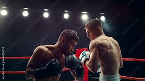 Cinematic Super Slow Motion Sports Footage with Two Professional Boxers Fighting in a Ring. Male Athlete Punching the Opponent in the Body. Sweat Spraying Everywhere From the Heavy Impact