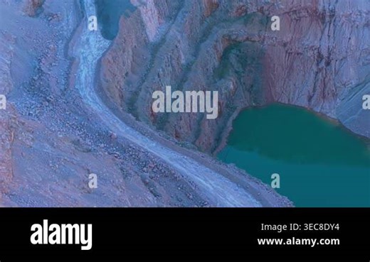 Serpentine quarry basin filling with green water between steep rock walls. Winding open pit excavation collecting water along layered mineral slopes. Developing artificial lake inside deep quarry carved into stone terraces Stock Video Footage - Alamy