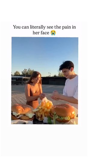 SP on Instagram: "This short-form video depicts a classic competitive eating challenge between two people sharing a meal outdoors. The intense, rapid consumption shown by the man, complete with exaggerated chewing and food smeared on his face, is contrasted sharply with the woman’s visible frustration and failure to secure a fair share of the food. The clip garnered over 8.5 million views and 700K shares in its initial release, sparking viral discussion. Audiences expressed highly relatable reac