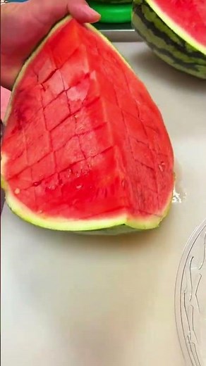 Cutting a fresh watermelon into perfect cubes with a sharp knife for an easy fruit snack
